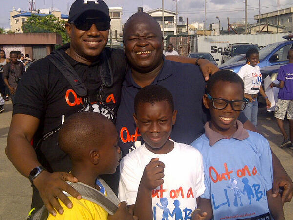 Image of the Founder Boye taking picture with 3 young boys and one man