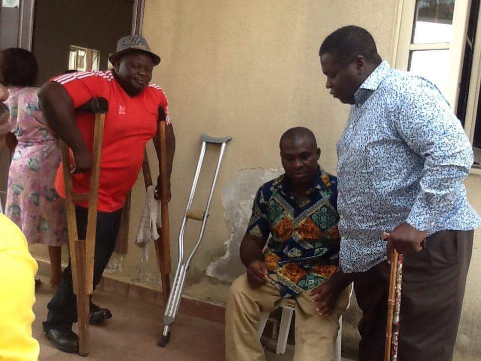 Image of the Founder talking to two disable persons